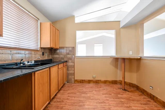 a view of a kitchen with wooden floor and a sink