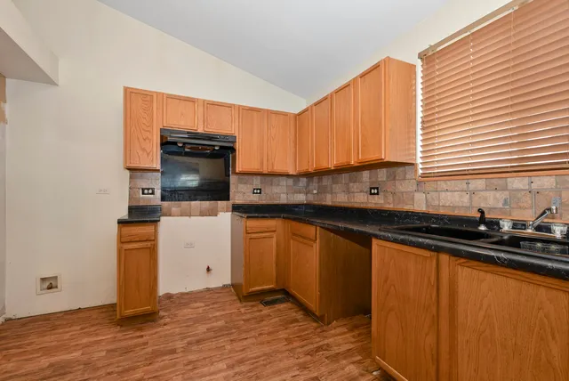a kitchen with granite countertop a sink stove and cabinets