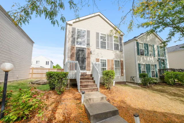 a front view of a house with a yard and potted plants