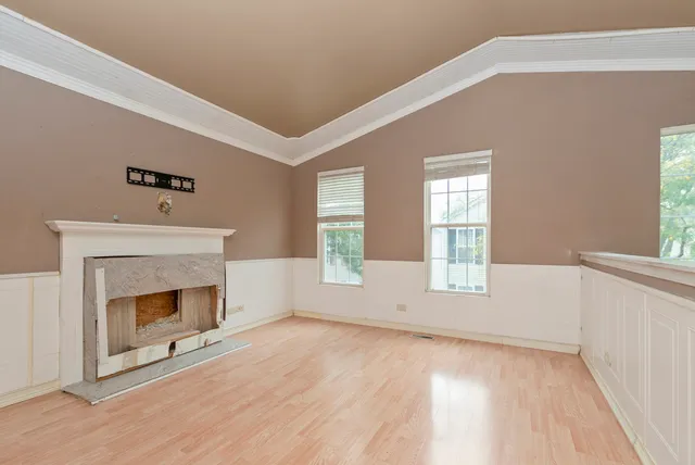 a view of empty room with wooden floor and fireplace
