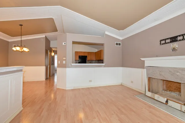 a view of a kitchen with a cabinet a fireplace and wooden floor