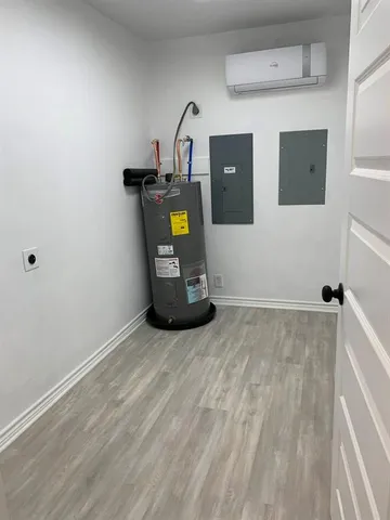 an empty room with wooden floor chandelier fan and windows