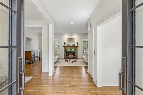 a view of a hallway with wooden floor fireplace and dining room