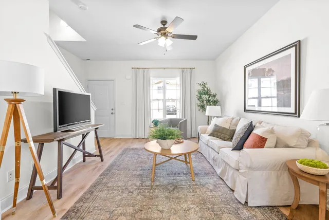 a living room with furniture a flat screen tv and a large window