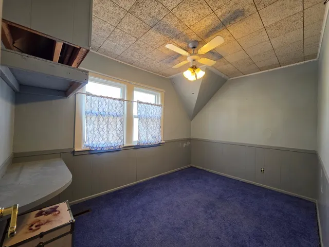 en empty room with windows and fan