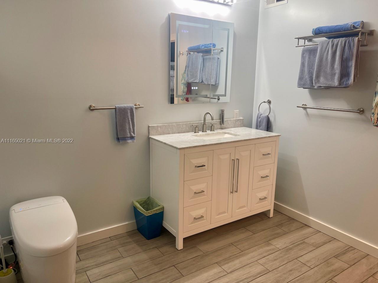 3 Sunset Lane Lauderdale-by-the-Sea, FL 33062 - Photo 16 of 36 a bathroom with a toilet sink and mirror