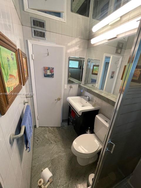 3 Sunset Lane Lauderdale-by-the-Sea, FL 33062 - Photo 18 of 36 a white toilet sitting next to a bathroom sink