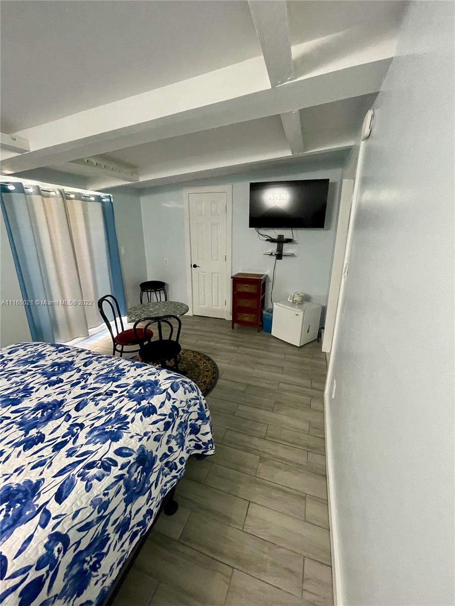 3 Sunset Lane Lauderdale-by-the-Sea, FL 33062 - Photo 20 of 36 a bedroom with a bed and a flat screen tv