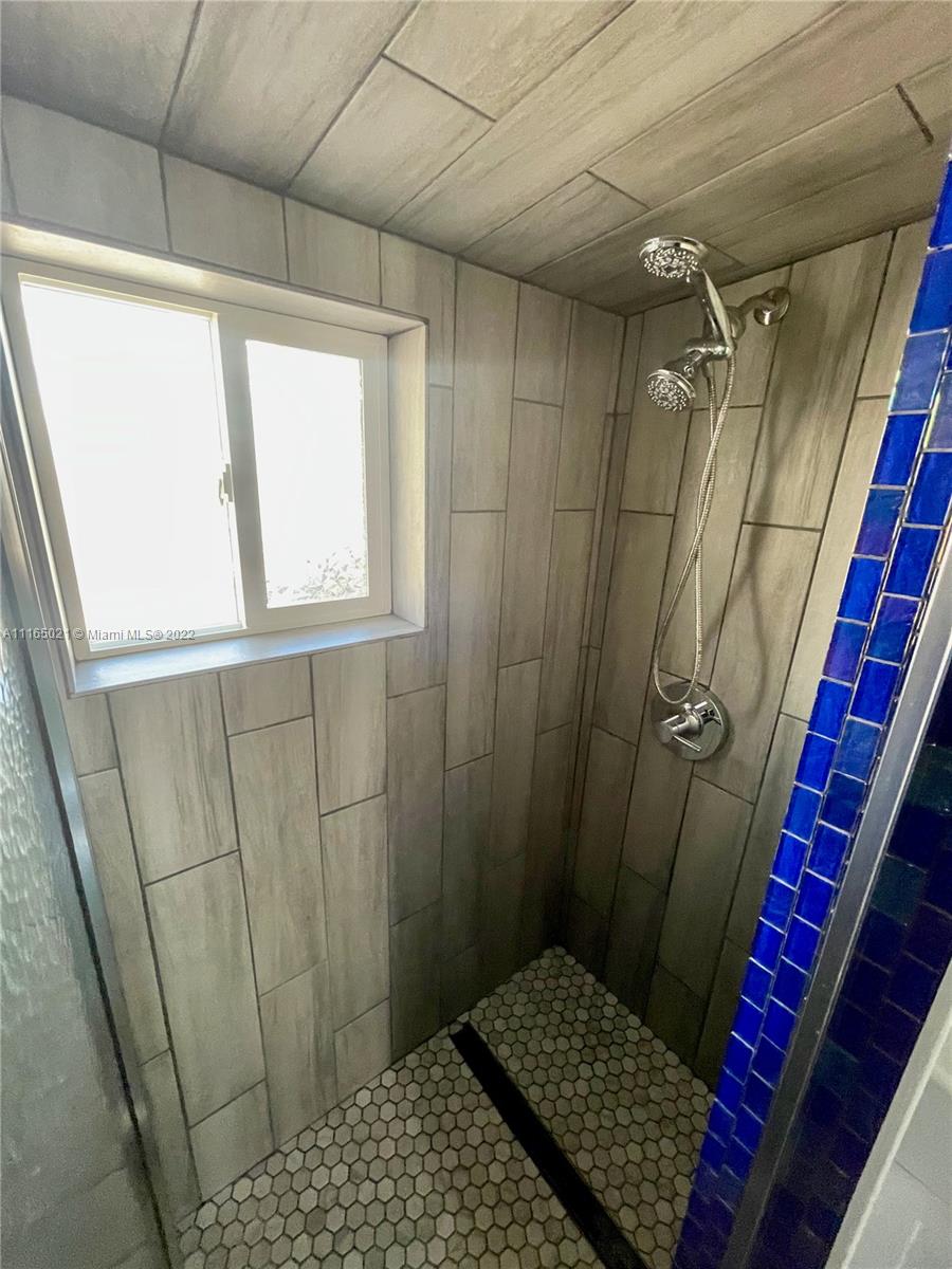 3 Sunset Lane Lauderdale-by-the-Sea, FL 33062 - Photo 22 of 36 a bathroom with a window and shower