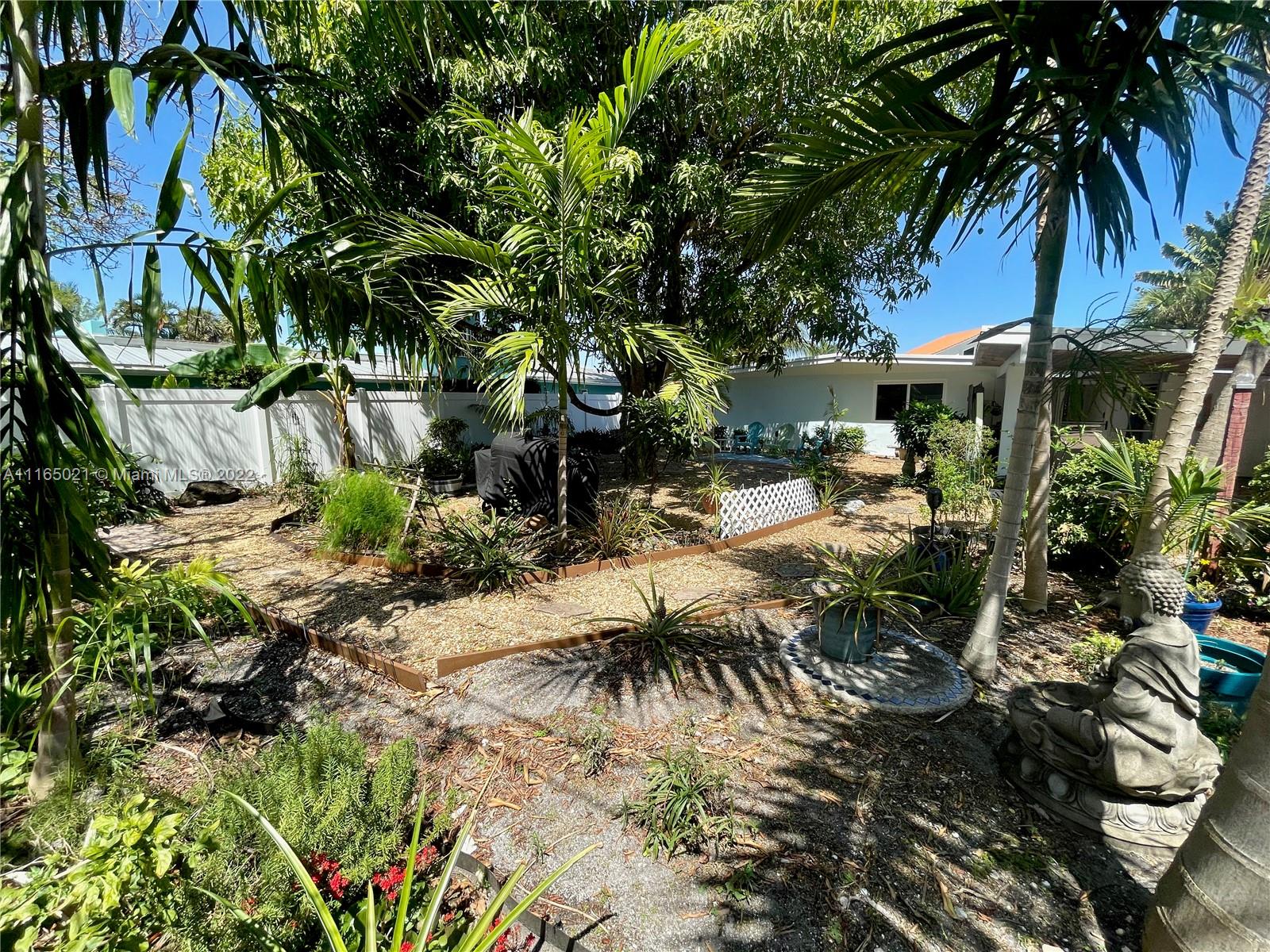 3 Sunset Lane Lauderdale-by-the-Sea, FL 33062 - Photo 27 of 36 a view of backyard of house with outdoor seating and trees