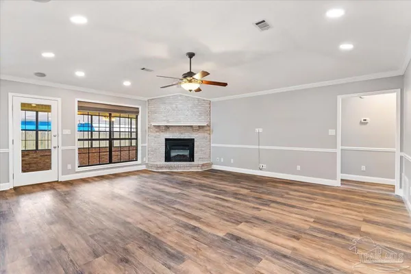 an empty room with wooden floor and fireplace