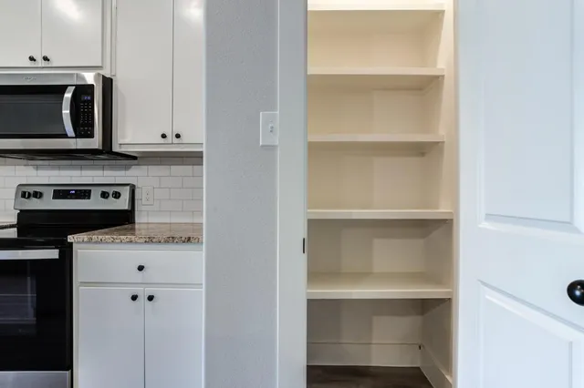 a kitchen with a microwave a stove and cabinets