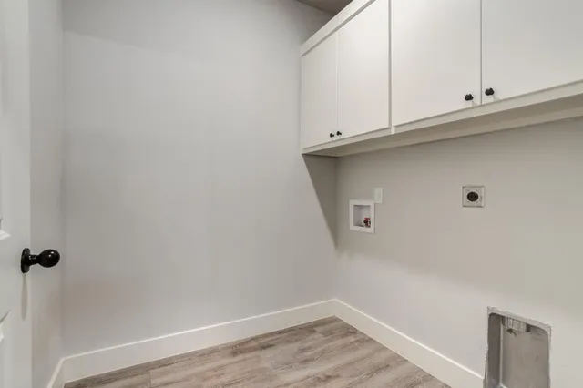 a view of a kitchen with white cabinets and a wooden floor