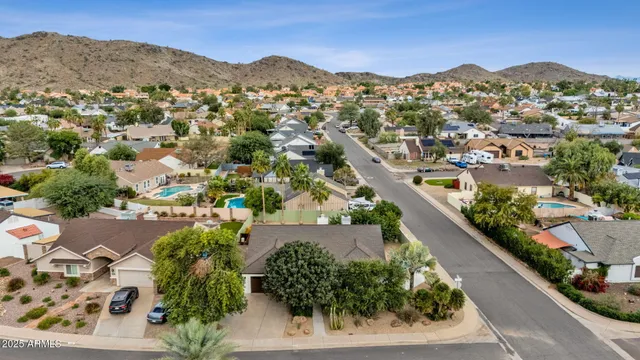 an aerial view of residential houses with outdoor space and parking