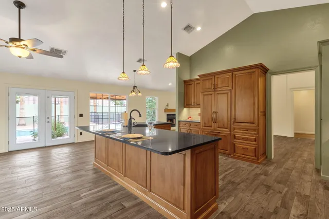a kitchen with stainless steel appliances granite countertop a sink a stove and a wooden floors