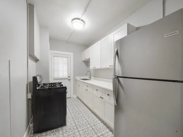 a kitchen with a refrigerator and a stove top oven