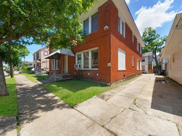 a front view of a house with a yard and trees