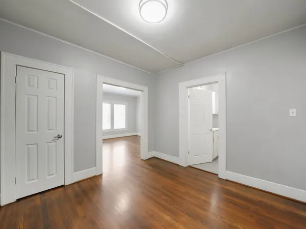 an empty room with wooden floor and closet area