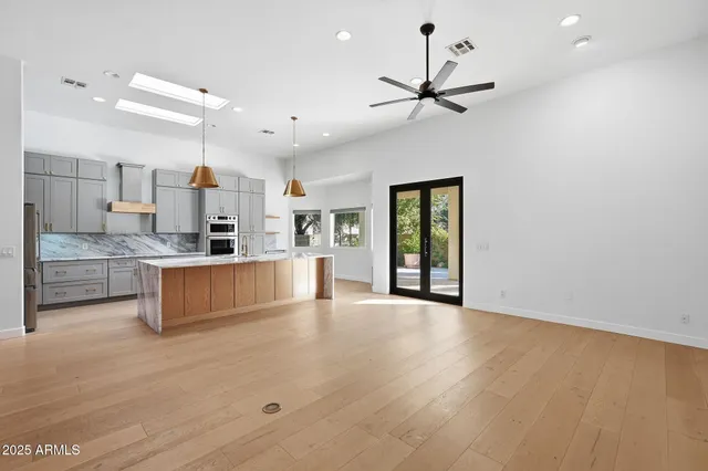 a large kitchen with cabinets and a wooden floor