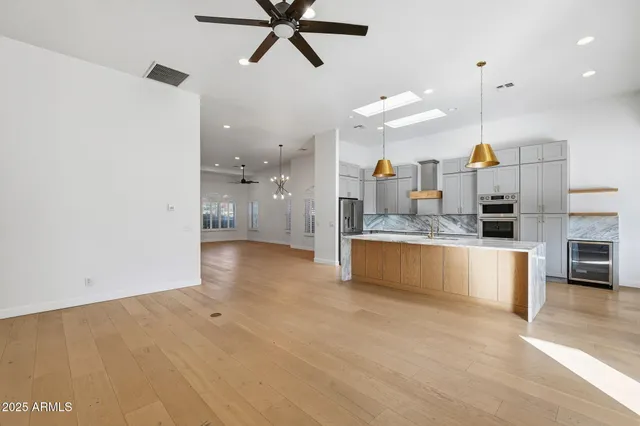 a large kitchen with kitchen island a large counter space a sink stainless steel appliances and cabinets