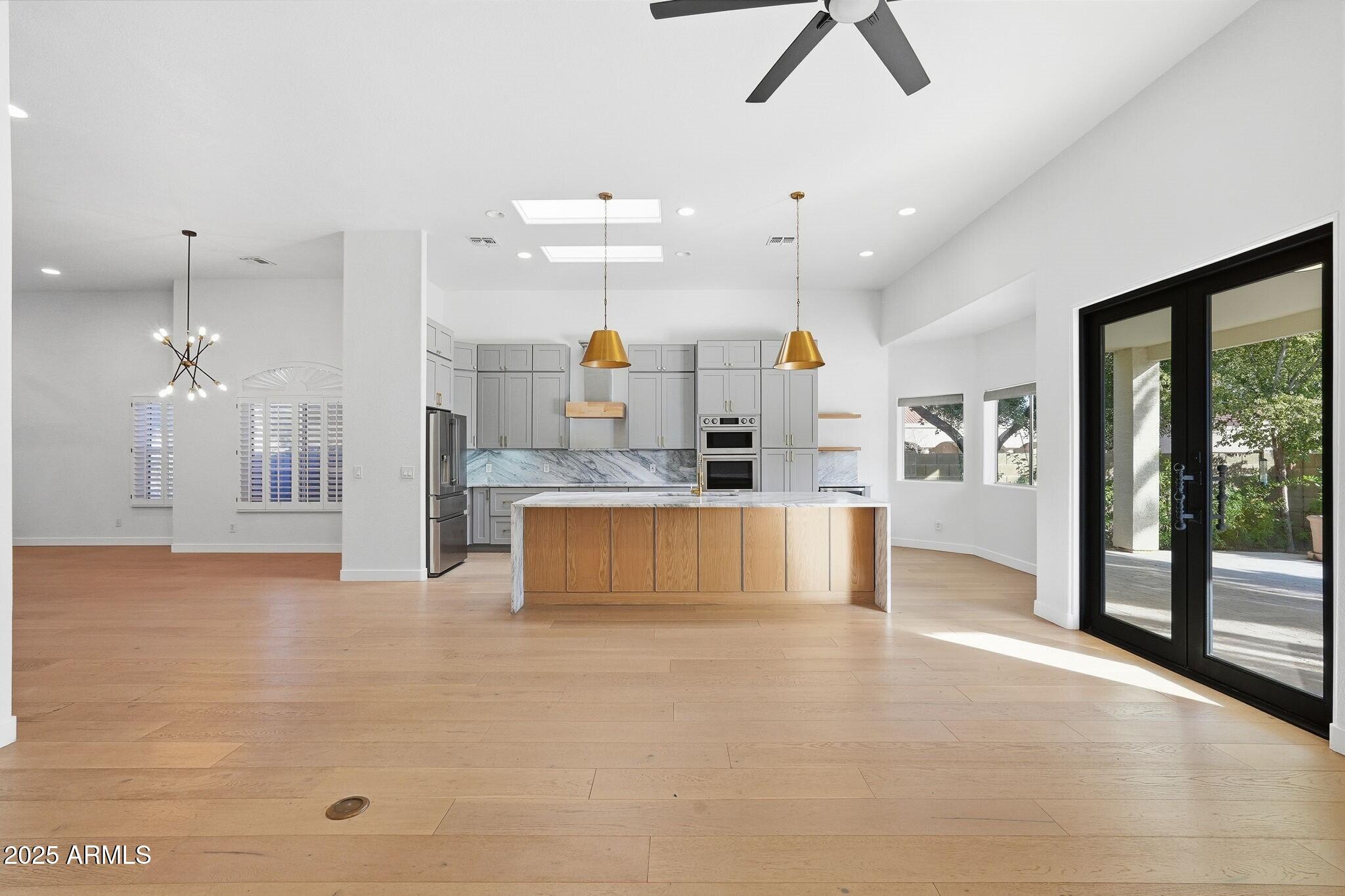 11415 North 44th Street Phoenix, AZ 85028 - Photo 12 of 56 a large kitchen with kitchen island a large counter space a sink stainless steel appliances and cabinets