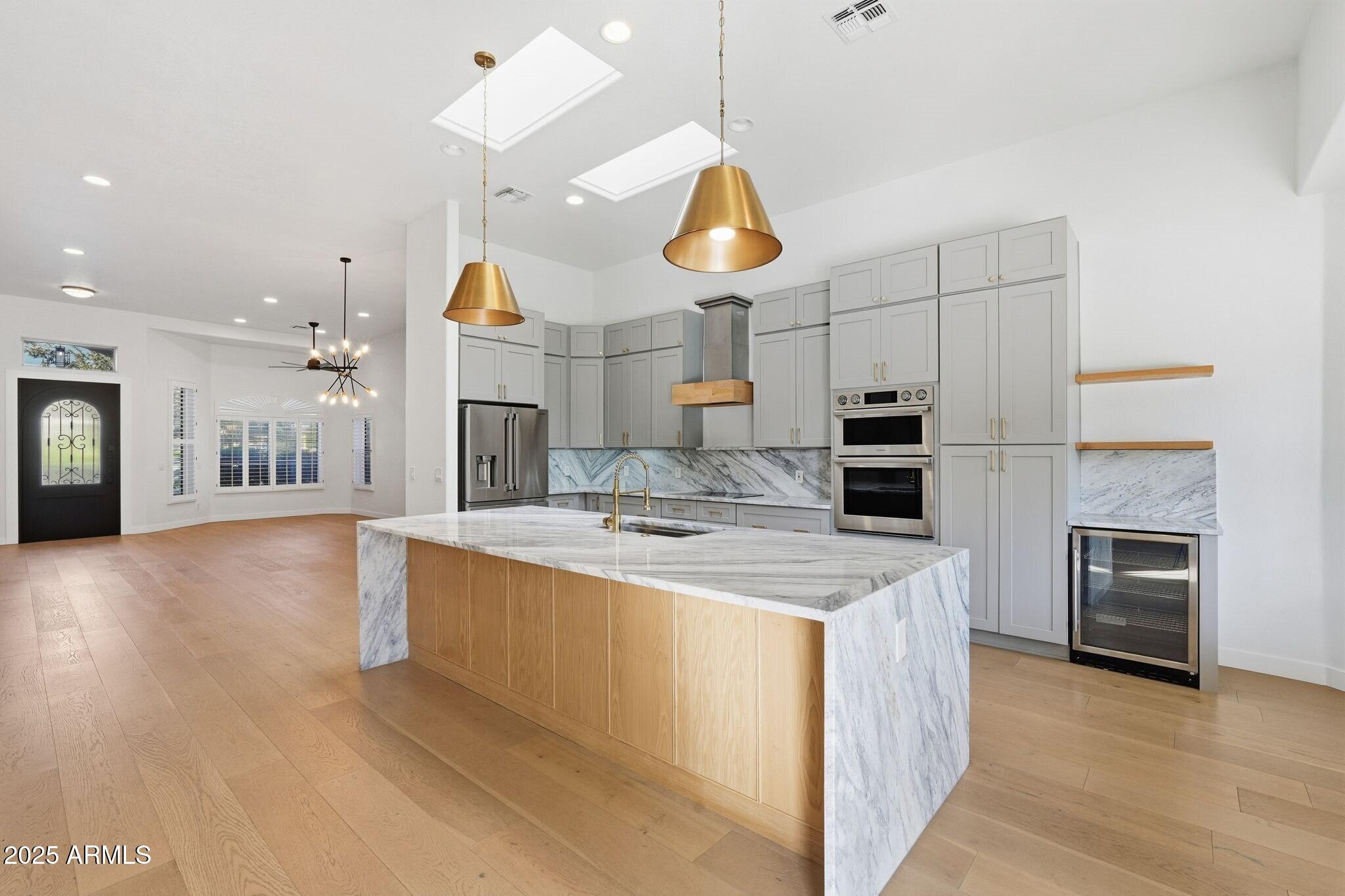 11415 North 44th Street Phoenix, AZ 85028 - Photo 13 of 56 a large kitchen with stainless steel appliances kitchen island a chandelier and a view of kitchen