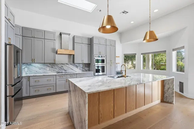 a kitchen with stainless steel appliances granite countertop a refrigerator and cabinets