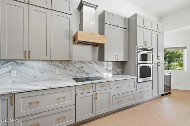 a kitchen with kitchen island a stove a counter space a sink and a window