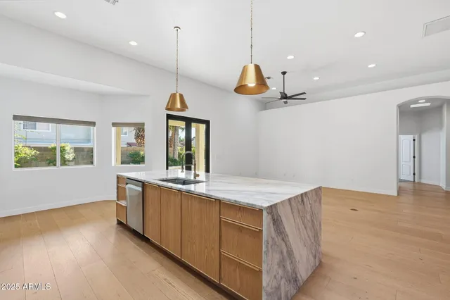 a kitchen with stainless steel appliances granite countertop a sink a stove and a refrigerator