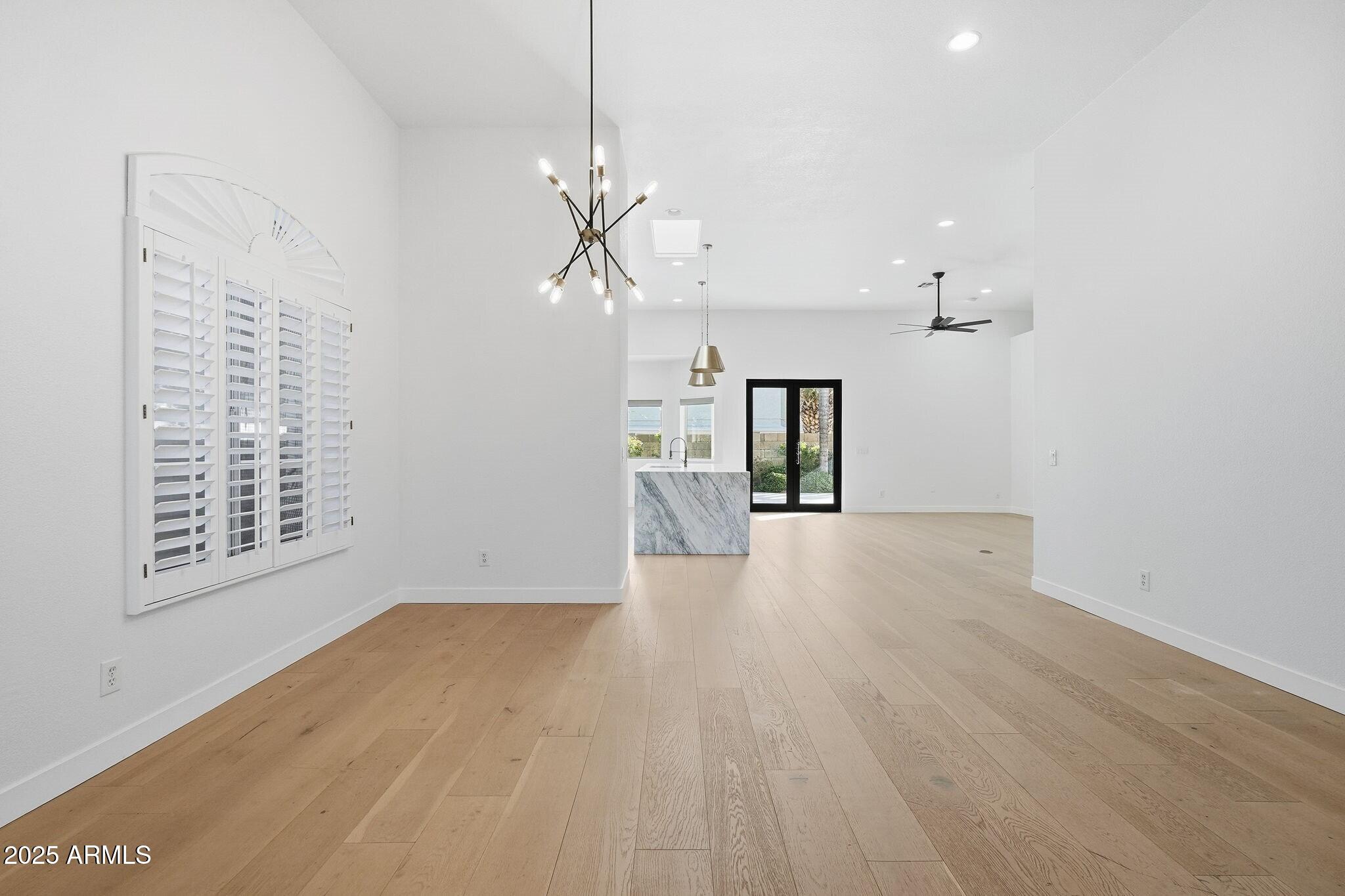 11415 North 44th Street Phoenix, AZ 85028 - Photo 22 of 56 a view of an empty room with wooden floor kitchen view and a window