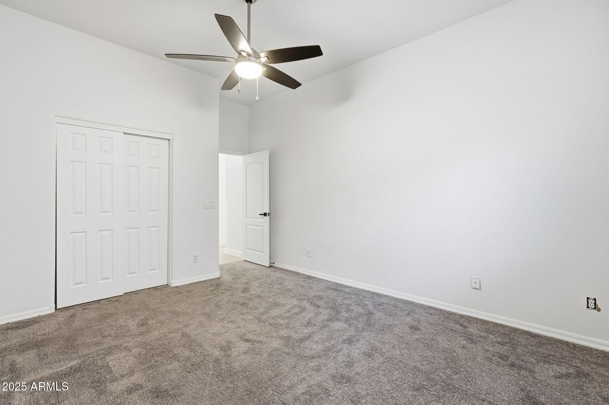 11415 North 44th Street Phoenix, AZ 85028 - Photo 37 of 56 an empty room with a ceiling fan and a window