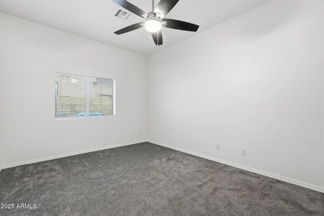 a view of empty room with ceiling fan