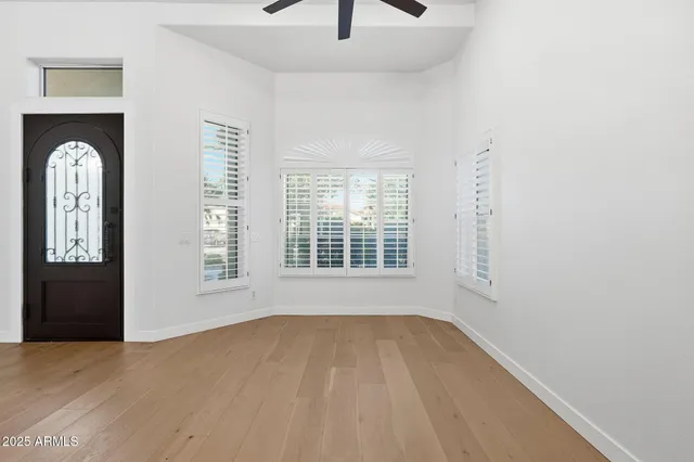 a view of an empty room with chandelier and a window