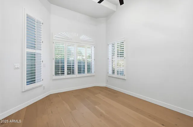 a view of an empty room with wooden floor and cabinet
