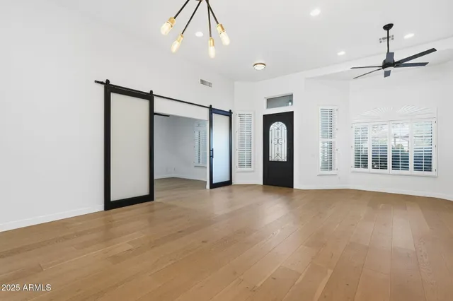 a view of an empty room with a window and kitchen view