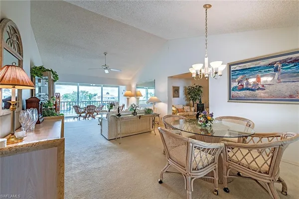 a view of a dining room and livingroom with furniture wooden floor a chandelier