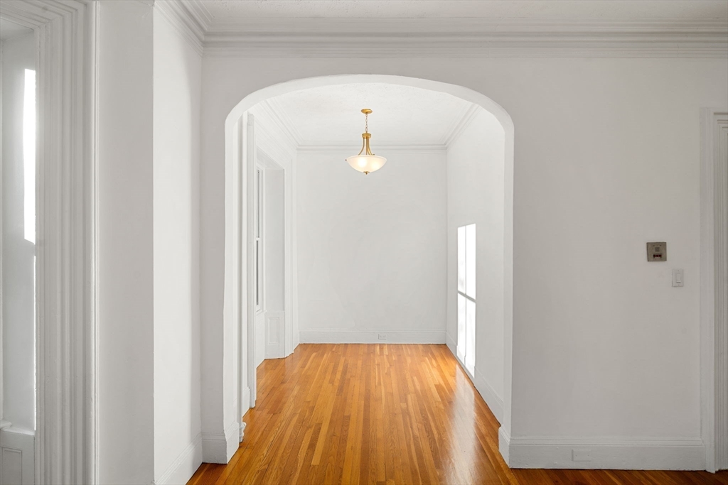 548 Massachusetts Avenue, Unit 3 Boston, MA 02118 - Photo 13 of 28 a view of a hallway with wooden floor