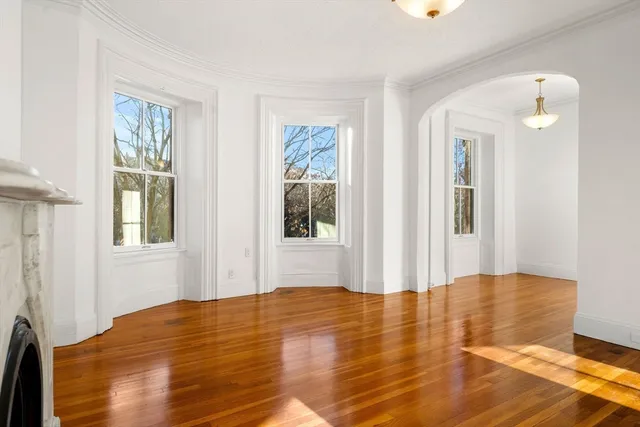 a view of a bedroom with wooden floor and windows