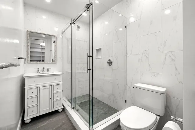 a bathroom with a shower sink mirror and toilet
