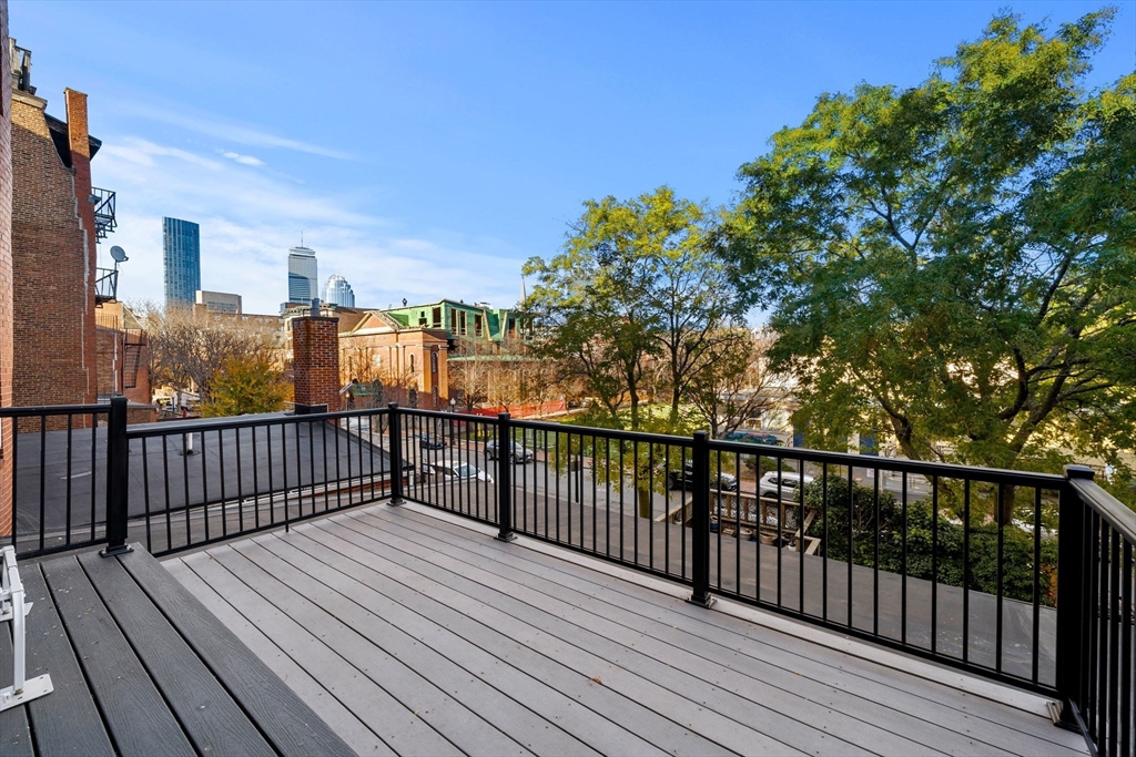 548 Massachusetts Avenue, Unit 3 Boston, MA 02118 - Photo 3 of 28 a view of a balcony with wooden floor and fence