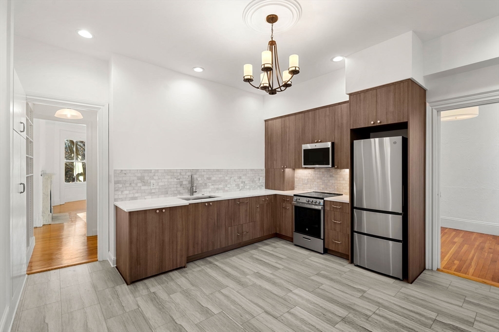 548 Massachusetts Avenue, Unit 3 Boston, MA 02118 - Photo 9 of 28 a kitchen with stainless steel appliances granite countertop a refrigerator and a sink