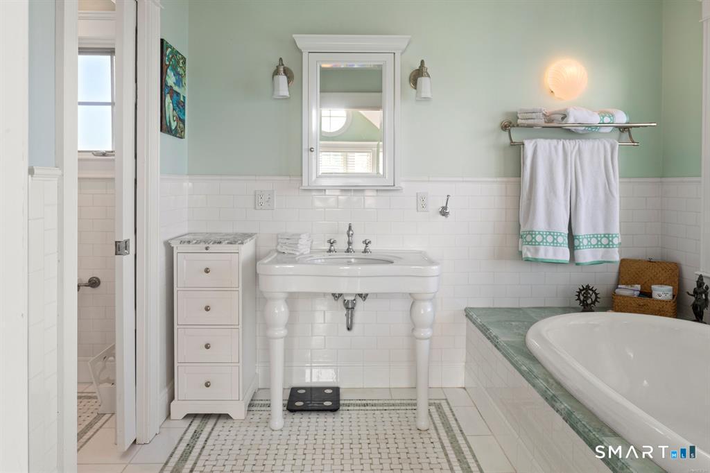 4 Point Road Old Saybrook, CT 06475 - Photo 31 of 58 a bathroom with a sink a mirror and a bathtub