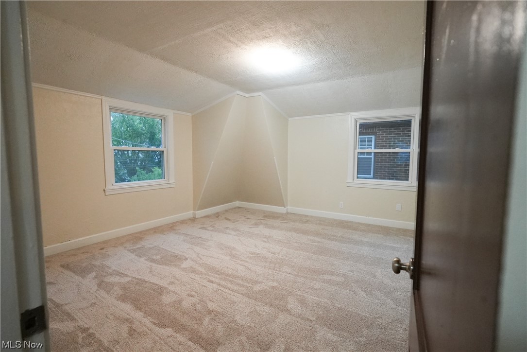 664 Ecton Road Akron, OH 44303 - Photo 24 of 35 Carpeted spare room with a textured ceiling and vaulted ceiling