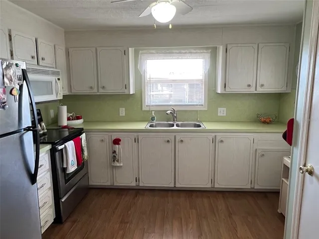 a kitchen with sink cabinets and wooden floor
