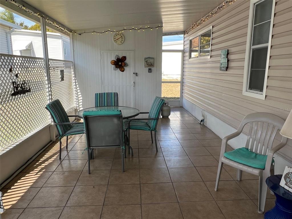 263 Sago Palm Street Largo, FL 33778 - Photo 8 of 29 a view of a patio with table and chairs and potted plants