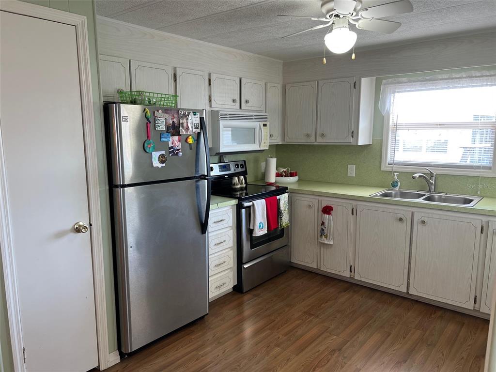 263 Sago Palm Street Largo, FL 33778 - Photo 10 of 29 a kitchen with stainless steel appliances granite countertop a refrigerator sink and cabinets