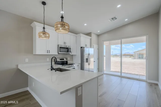 a kitchen with stainless steel appliances granite countertop a sink a stove a refrigerator and cabinets