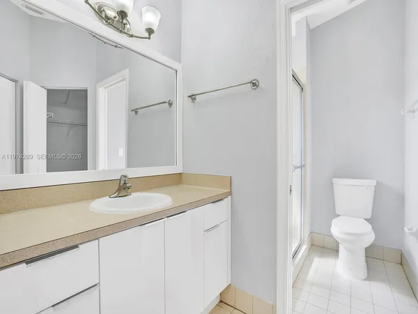 a bathroom with a granite countertop sink a toilet and a mirror