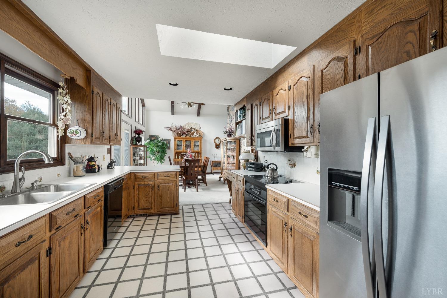 7903 Charlemont Road Goode, VA 24556 - Photo 12 of 47 a kitchen with a sink stainless steel appliances cabinets and a window