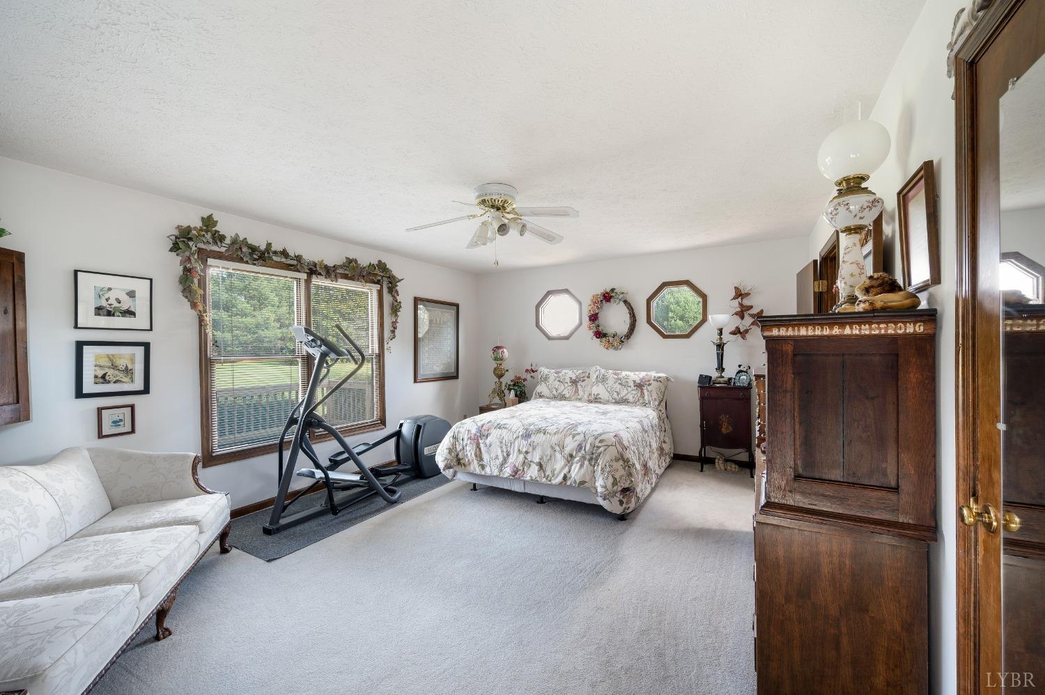 7903 Charlemont Road Goode, VA 24556 - Photo 17 of 47 a bedroom with a bed a couch and a window